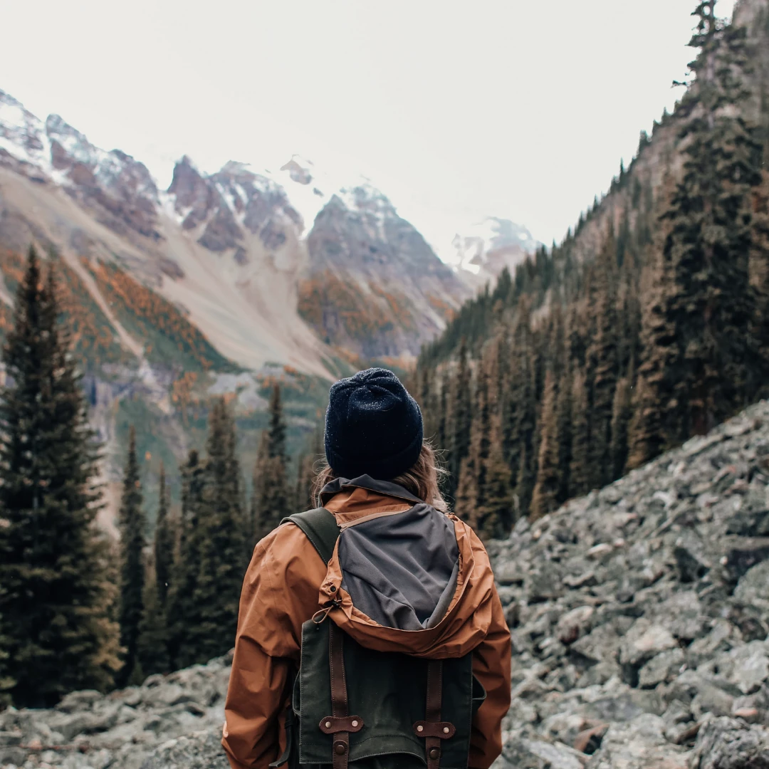 Kvinne ute på fjelltur med fjell i bakgrunnen
