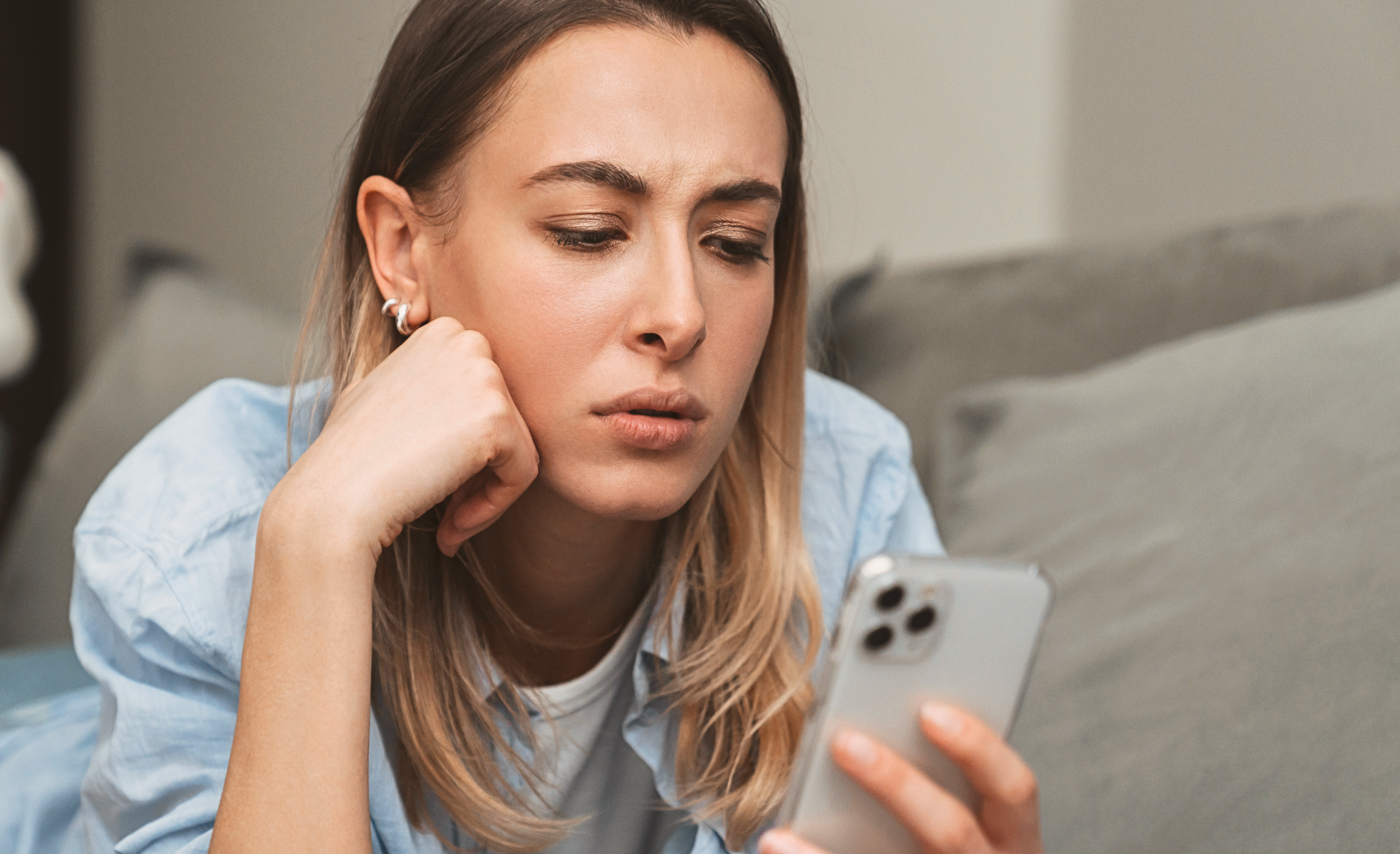 kvinne ser bekymret på mobil