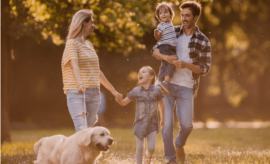Smilende familie og Golden Retriever-hund