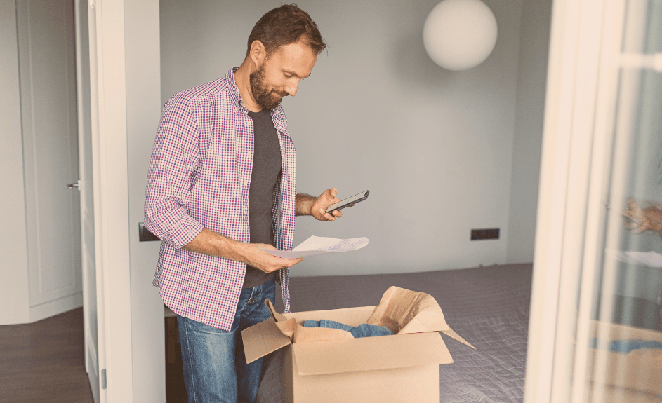 Mann pakker opp en pakke