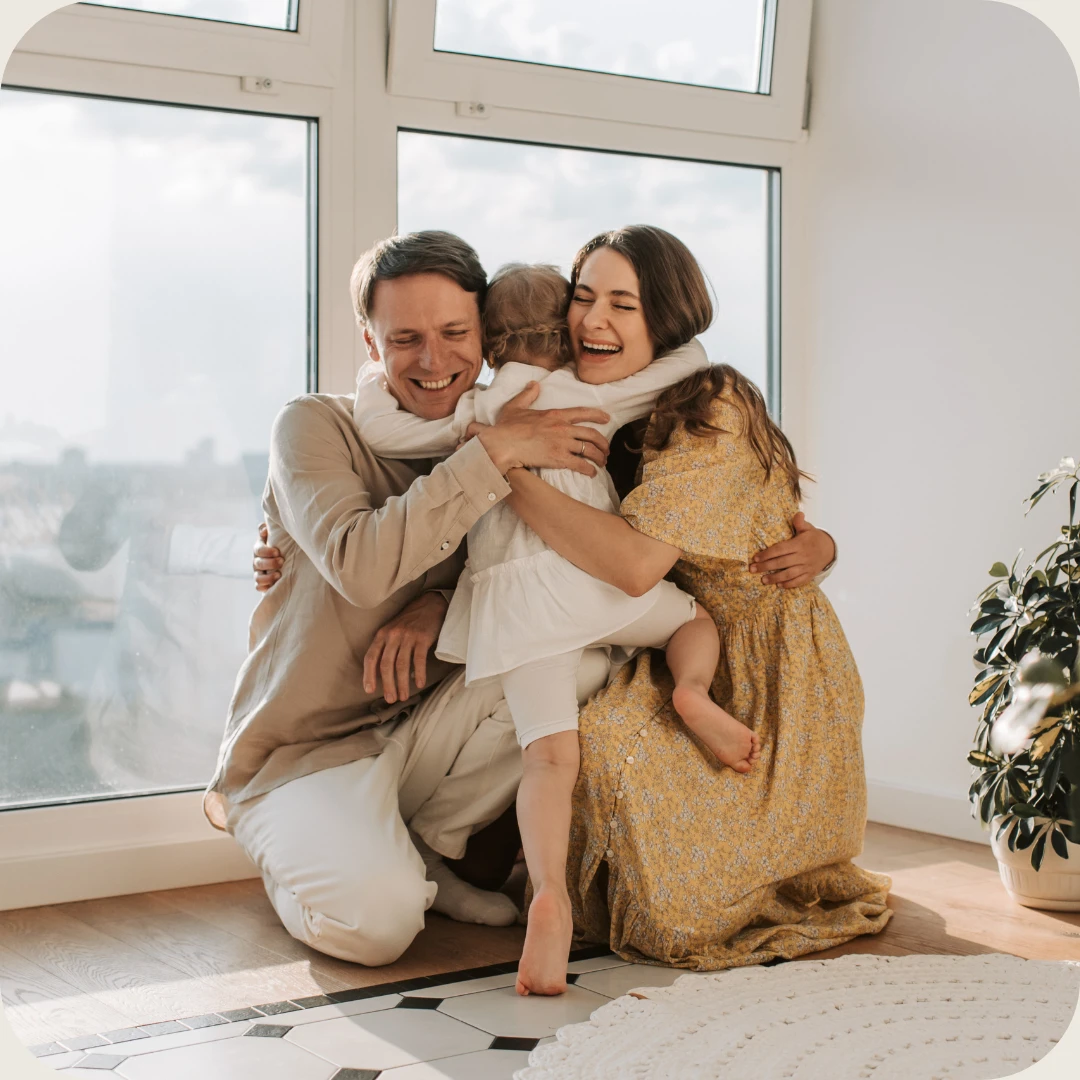 smildende familie klemmer hverandre