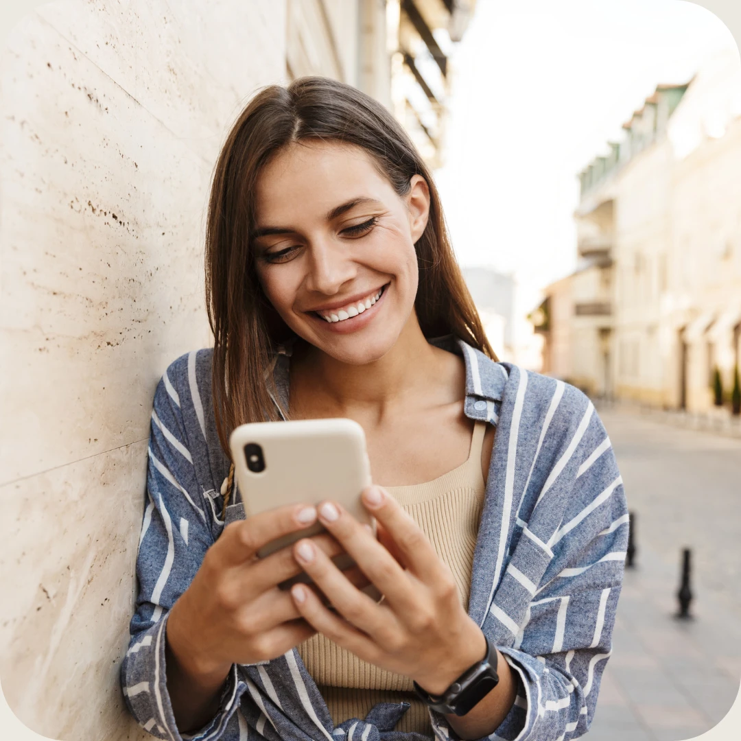 smildende kvinne ser på mobil