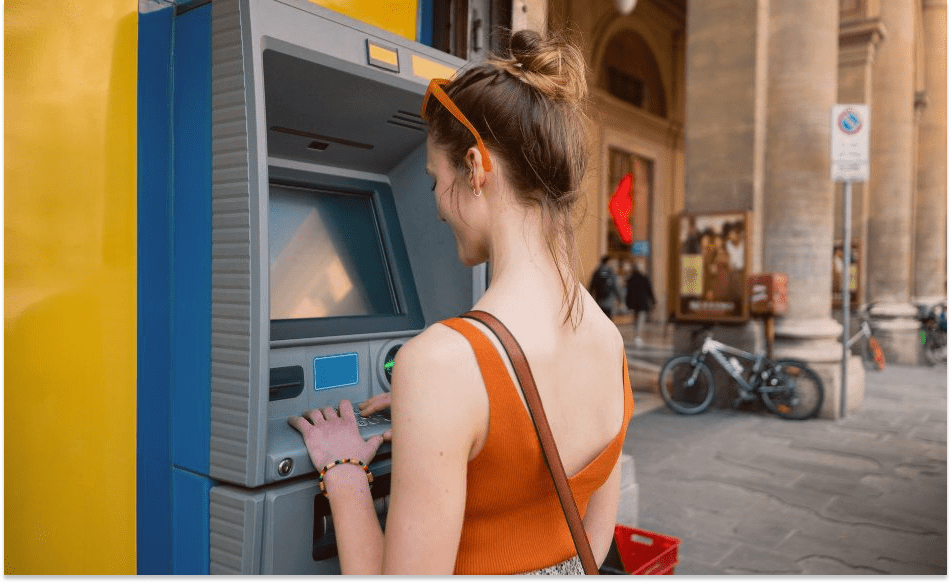 kvinne bruker kort i utlandet minibankuttak 