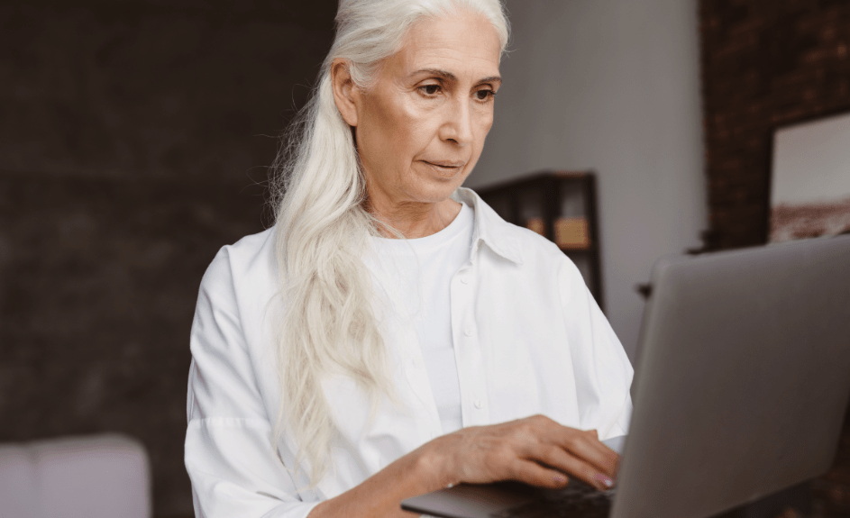 Eldre dame ser skeptisk på pc for å avsløre svindelforsøk