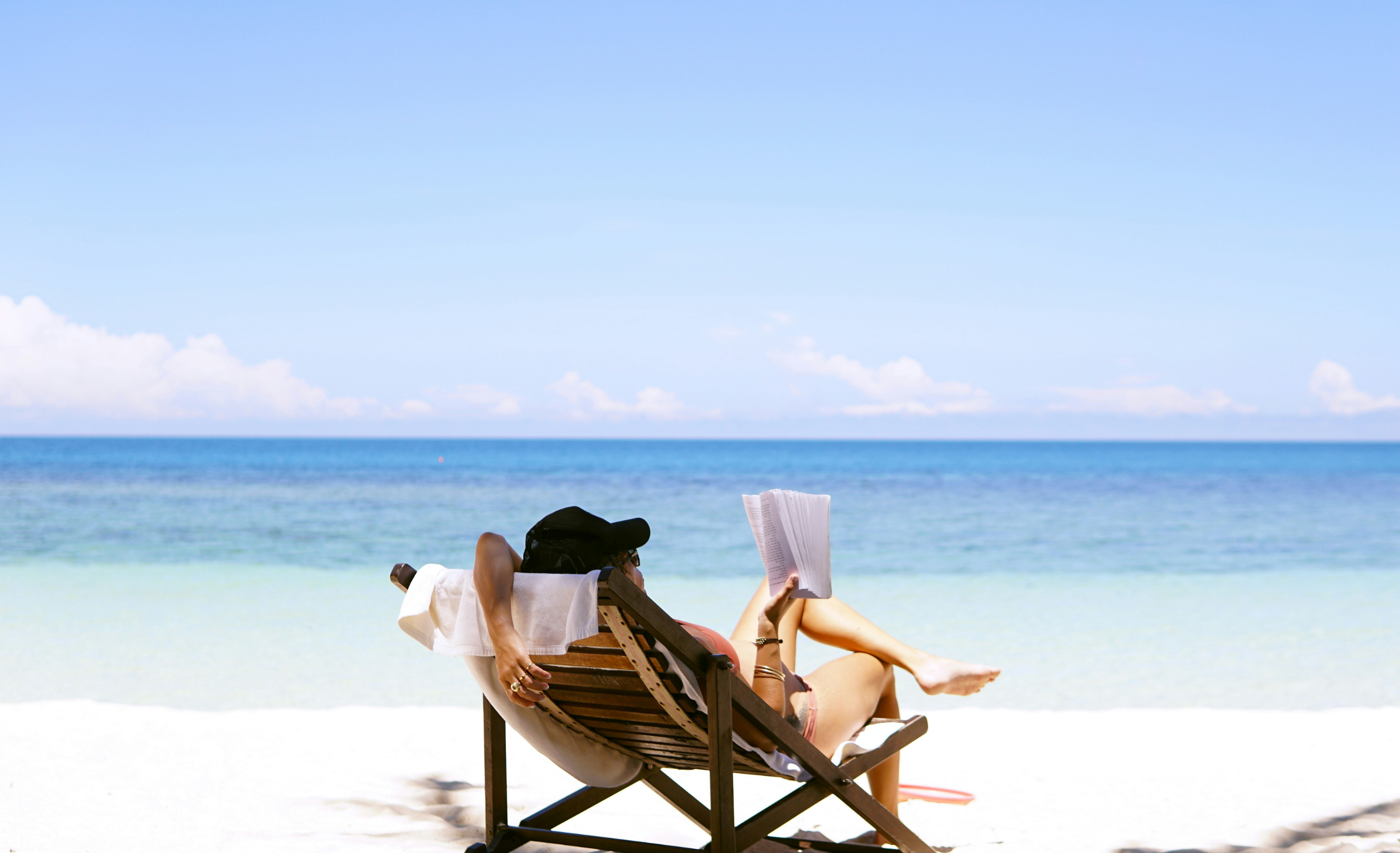 Dame leser bok på tropisk strand