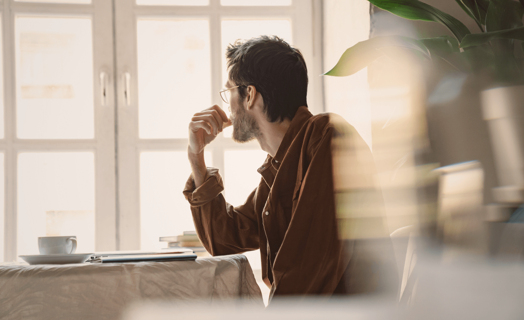 Mann ser ut vindu og undrer hvordan man beregner rente på kredittkort